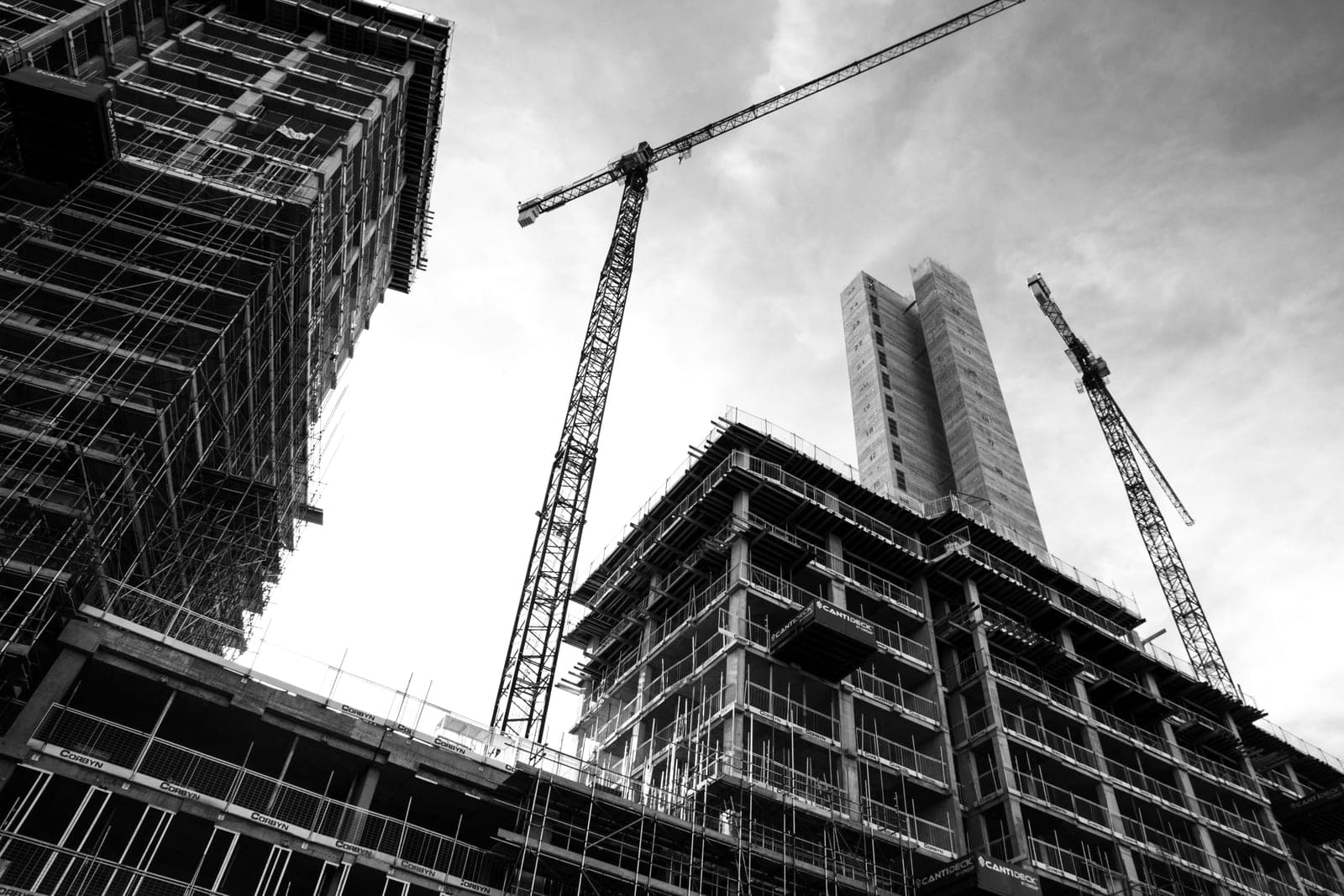 Commercial construction — scaffolding and cranes against the sky